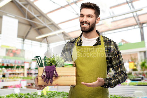 Image of gardener with box of tools at flower shop