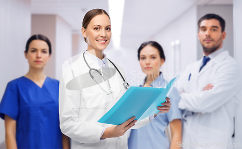 Image of smiling female doctor with colleagues at hospital