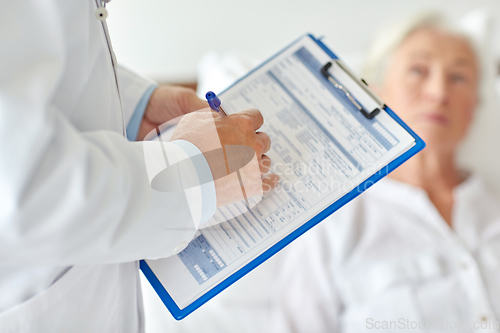 Image of senior woman and doctor with clipboard at hospital