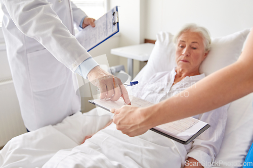 Image of senior woman and doctors at hospital