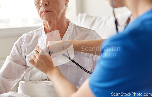 Image of doctor with stethoscope and old woman at hospital