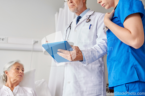 Image of doctors with table pc and senior woman at hospital