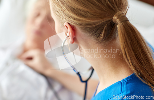 Image of doctor with stethoscope and old woman at hospital