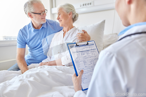 Image of old couple and doctor with clipboard at hospital