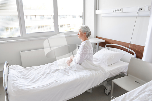 Image of lonely senior woman sitting in bed at hospital