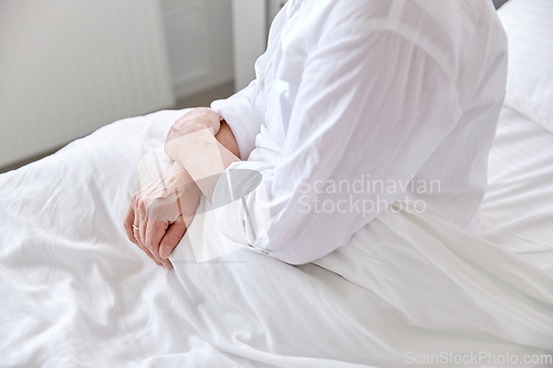 Image of lonely senior woman sitting in bed at hospital