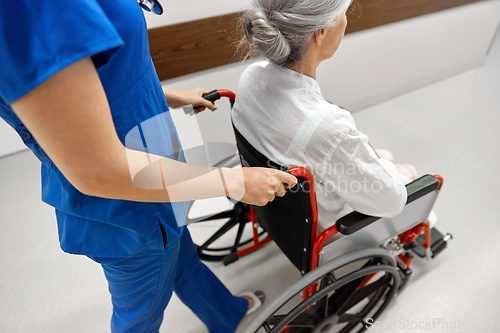 Image of nurse with senior patient in wheelchair at clinic