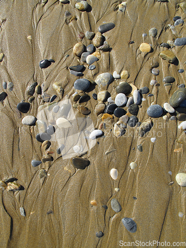 Image of Wet sea pebbles on the sand