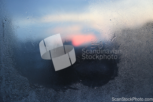 Image of Melting ice patterns, water drops and sunlight on glass