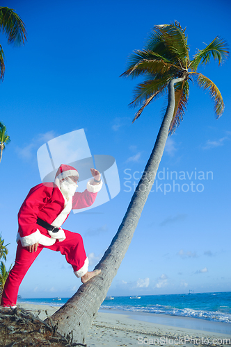 Image of Santa Claus is on vacation on a tropical beach.