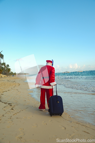 Image of Santa Claus is on vacation on a tropical beach.