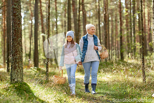 Image of grandmother and granddaughter picking mushrooms