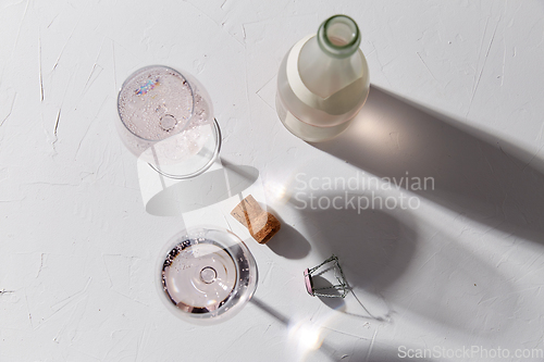 Image of wine glasses and champagne bottle dropping shadows