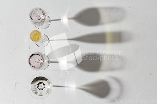 Image of wine glasses dropping shadows on white surface