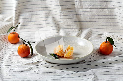 Image of still life with mandarins on plate over drapery