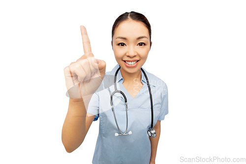 Image of happy asian female doctor pointing finger up