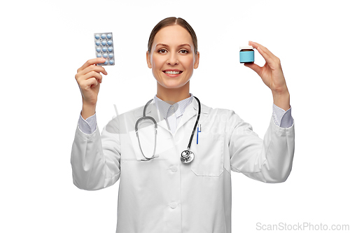 Image of smiling female doctor holding medicine pills