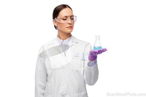 Image of female scientist in goggles with chemical in flask