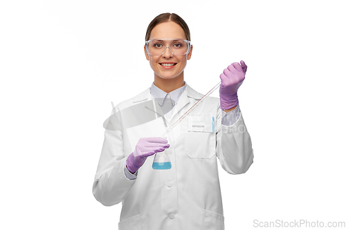 Image of female scientist in goggles with chemical in flask