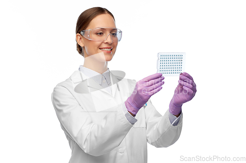 Image of female scientist in goggles with chemical sample