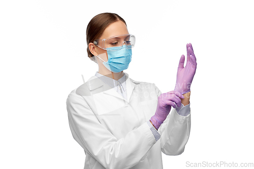 Image of female doctor in gloves, mask and goggles