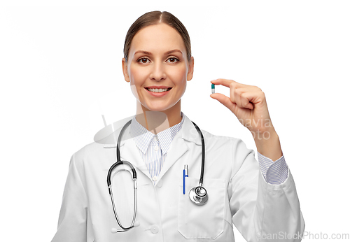 Image of smiling female doctor holding medicine pill