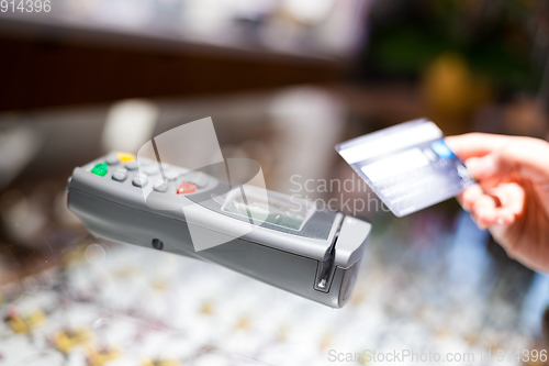 Image of Woman paying with NFC technology on credit card