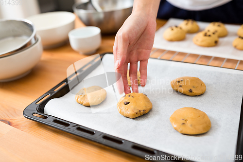 Image of Putting dough on metal tray 