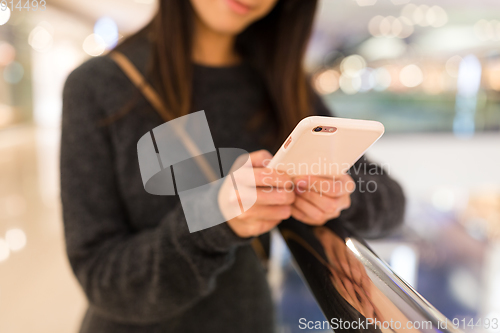 Image of Woman working on cellphone in shopping mall