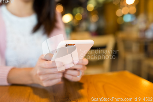 Image of Woman sending text message on mobile phone