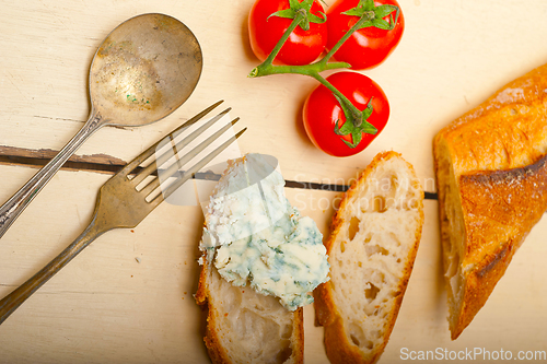 Image of fresh blue cheese spread ove french baguette