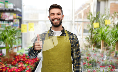 Image of happy gardener showing thumbs up at flower shop