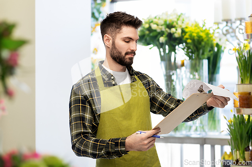 Image of male gardener with clipboard at flower shop