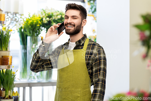 Image of male seller calling on smartphone at flower shop