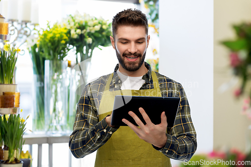 Image of florst or seller with tablet pc at flower shop