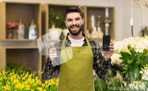 Image of seller with phone shows thumbs up at flower shop