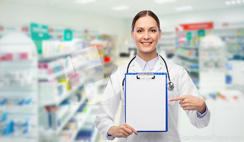 Image of happy female doctor with clipboard at pharmacy