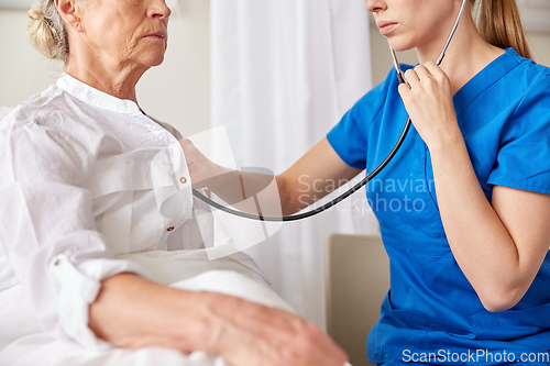 Image of doctor with stethoscope and old woman at hospital