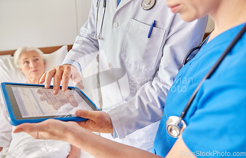 Image of doctors with table pc and senior woman at hospital