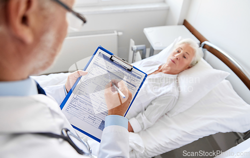 Image of senior woman and doctor with clipboard at hospital