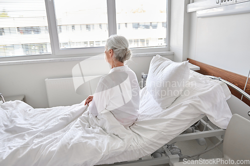 Image of lonely senior woman sitting in bed at hospital