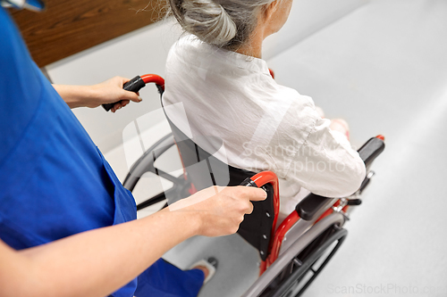 Image of nurse with senior patient in wheelchair at clinic