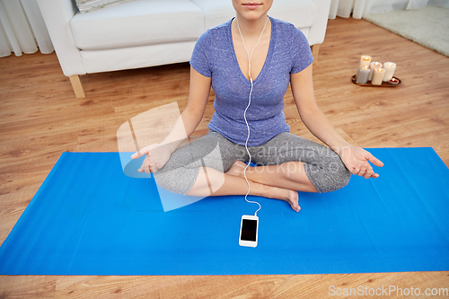 Image of woman listening to music and meditating at tome