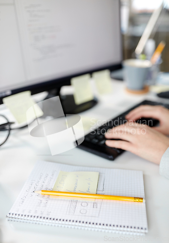 Image of businesswoman with notebook and computer at office