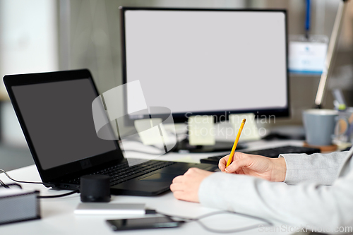Image of businesswoman with notebook and laptop at office