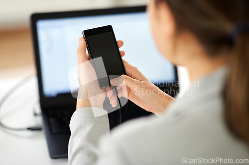 Image of businesswoman with smartphone working at office