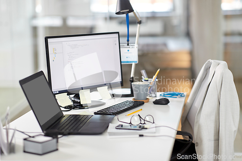 Image of laptop computer and gadgets on table at office