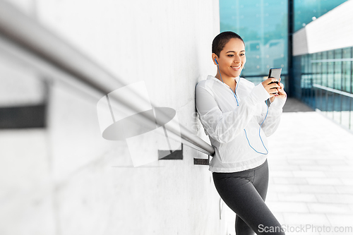 Image of african american woman with earphones and phone