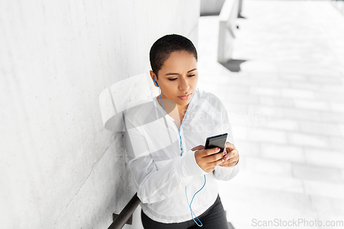 Image of african american woman with earphones and phone