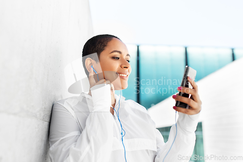 Image of african american woman with earphones and phone